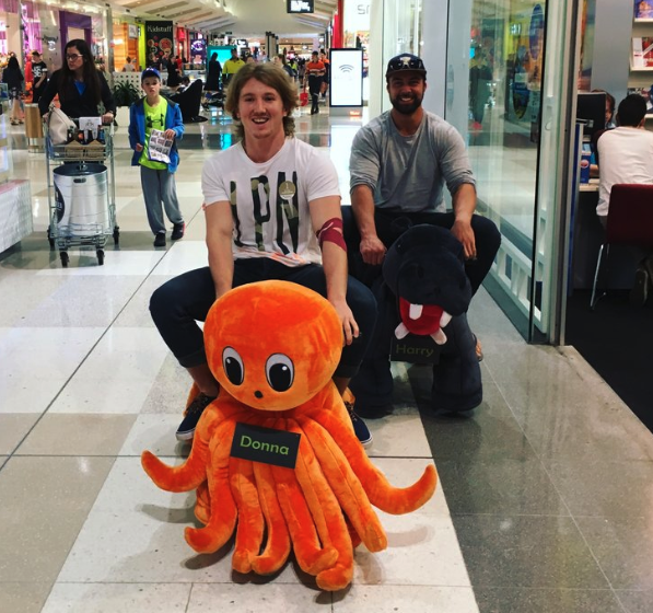 Daniel Bourke riding a stuff octopus through a shopping centre.