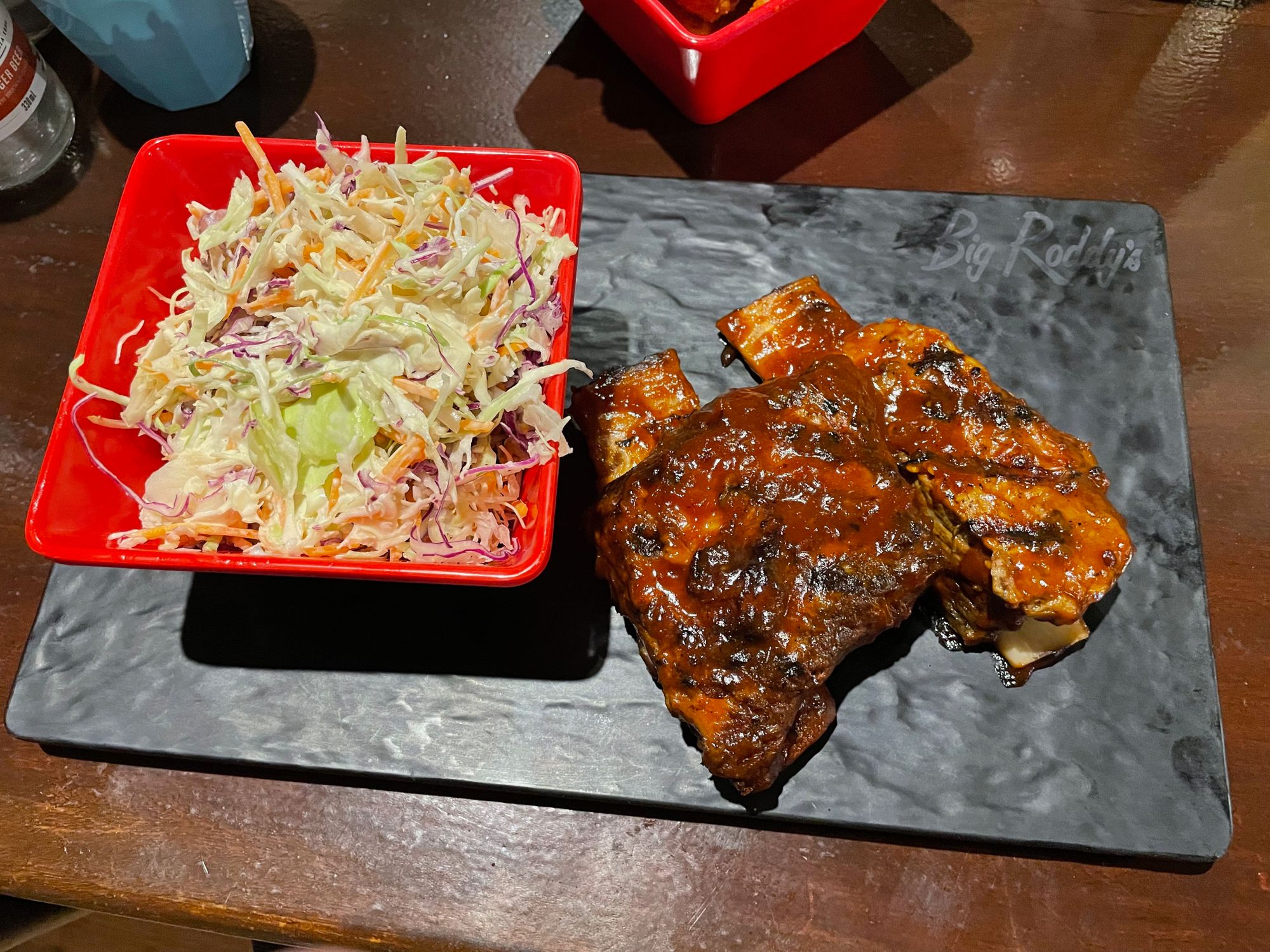 pork ribs with sauce and coleslaw on a rectangular plate from Big Roddy's